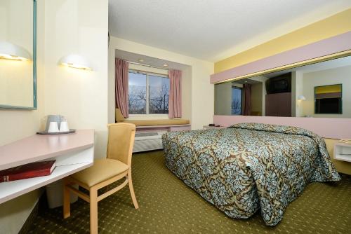 东叙拉古美洲最佳价值酒店 - 锡拉库扎东的配有一张床和一张书桌的酒店客房