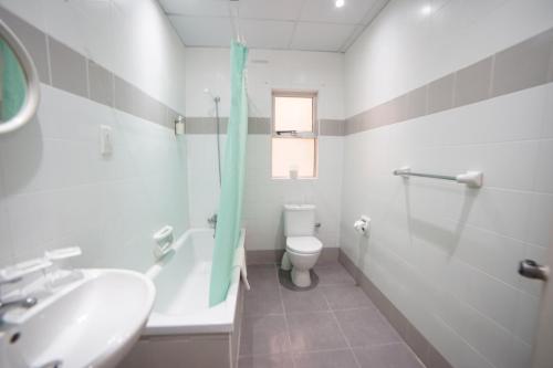 圣保罗湾城卡多假日酒店的浴室配有盥洗盆、卫生间和浴缸。