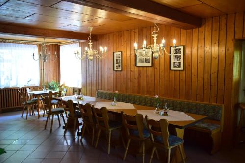 UttewaldeGasthof Uttewalde的用餐室设有木墙和桌椅