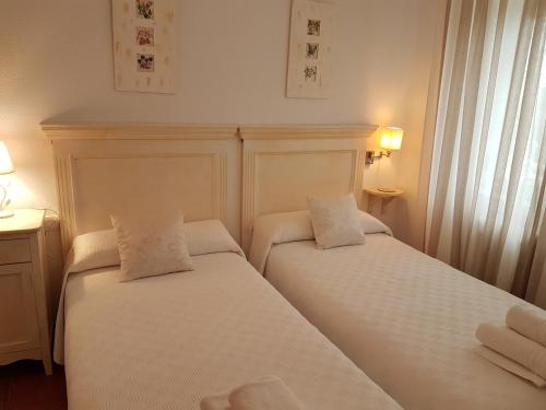 佩拉布若瓦Tres Hermanos CON PISCINA PRIVADA的配有白色床单的酒店客房内的两张床