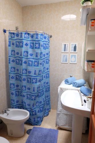 阿列塔SEA & RELAX - Apartament 1 drcha的浴室设有蓝色的浴帘和水槽