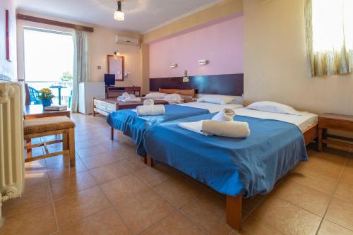 基内塔阳光酒店的配有蓝色床单的客房内的两张床