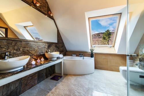 卡尔帕奇Pałac Margot Nature&SPA的浴室配有2个盥洗盆和1个浴缸。