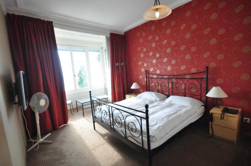 蒙特勒辉煌酒店的一间卧室设有一张床和红色的墙壁