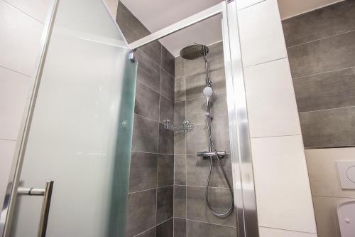 波普拉德HOTEL 63的浴室里设有玻璃门淋浴