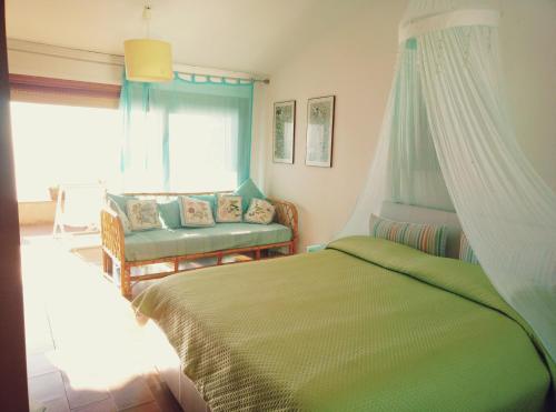 蒙泰亚尔真塔廖Porto S.Stefano CalaPiccola的卧室配有床、椅子和窗户。