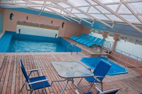普诺泰彼卡拉拉戈酒店的大楼内一个带椅子和桌子的游泳池