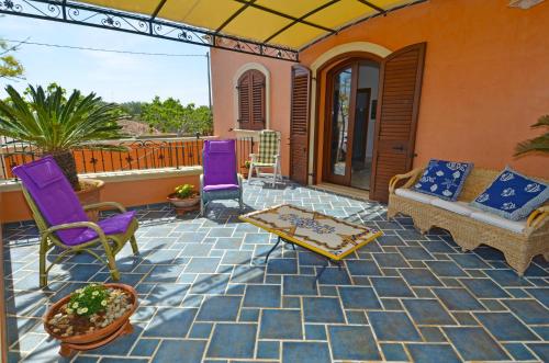 帕图Casa Spano 1 - RosariaVacanze的庭院配有紫色椅子和沙发