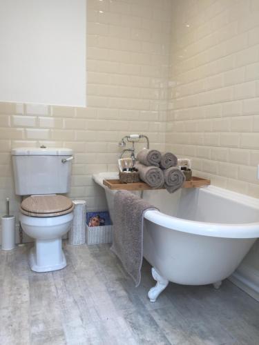 拉伊Barons Granary的浴室配有白色浴缸和卫生间。