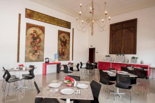 克雷塔罗克雷塔罗扎尔酒店的一间带桌椅和吊灯的用餐室