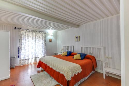 Ahigal de los AceiterosPosada de Los Aceiteros的一间卧室配有橙色和白色床单。