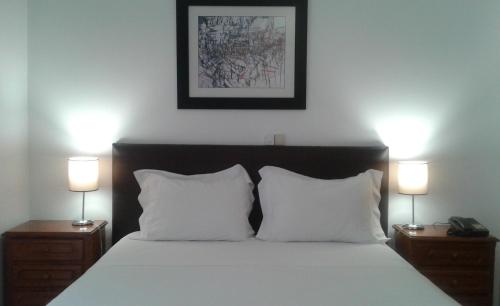 布拉干萨Hotel Tic Tac的一间卧室配有一张床,在床头柜上配有两盏灯