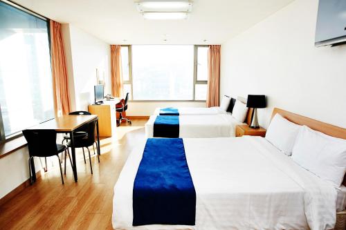 首尔现代住宅的酒店客房配有两张床和一张书桌