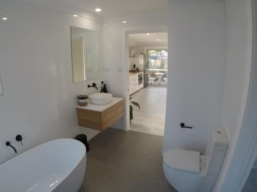克罗纳拉Lautan Cronulla Beach的带浴缸、卫生间和盥洗盆的浴室