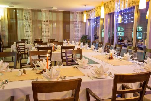 梅特利卡贝拉克拉伊纳酒店的用餐室配有桌椅和白色的桌布