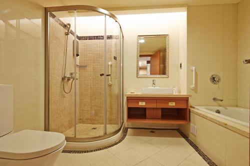 大寮乡义大天悦饭店的带淋浴、卫生间和盥洗盆的浴室