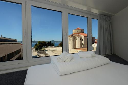 扎达尔广场精品旅馆的卧室配有白色的床和大窗户