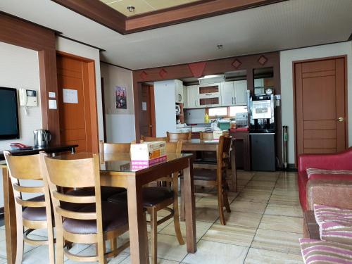 釜山普拉斯汽车旅馆的厨房以及带桌椅的用餐室。