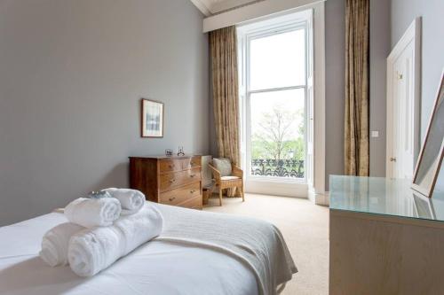 爱丁堡JOIVY Spacious 2BR Apt in New Town, Prime Location的卧室配有带毛巾的窗户。
