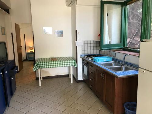 乌斯蒂卡Case del Tramonto的一个带水槽和镜子的小厨房