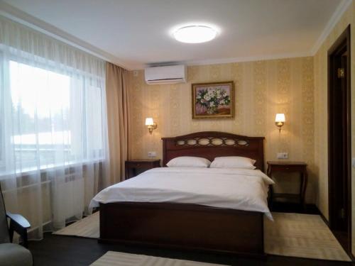 克麦罗沃库兹巴斯酒店的一间卧室设有一张大床和一个窗户。