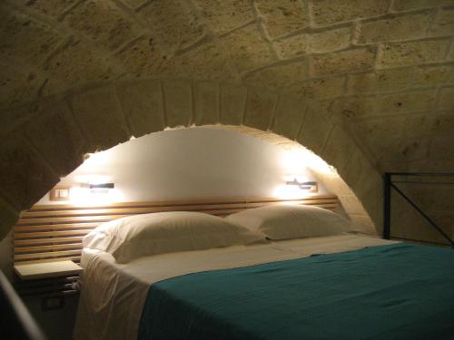 特拉尼Antico Molino的一间卧室配有一张砖墙床