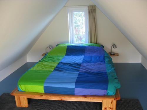 洛珀瑟姆Villa Selva的一张带五颜六色的被子的床