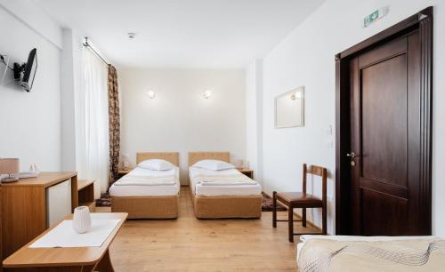 弗尔蒂切尼Hotel Turist的一间设有两张床、一张桌子和一扇门的房间