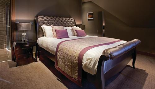 汉密尔顿帕克维尔酒店的一间卧室配有一张带紫色枕头的大床
