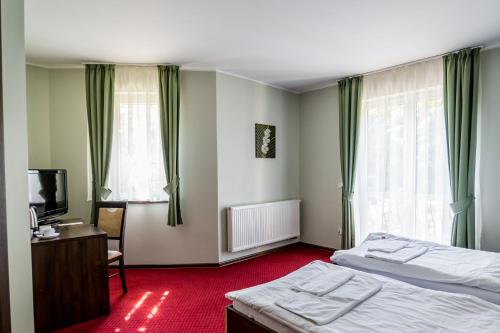 格但斯克雷比赫瓦 韦尔塞酒店的一间卧室配有两张床、一张桌子和一台电视。
