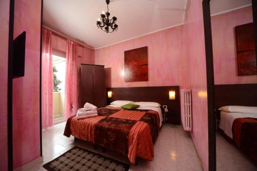 里米尼冲绳酒店的粉红色的卧室设有床和窗户