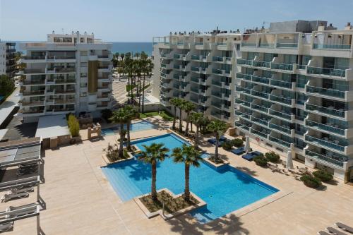 萨洛布鲁玛酒店的享有棕榈树和建筑的游泳池的顶部景致
