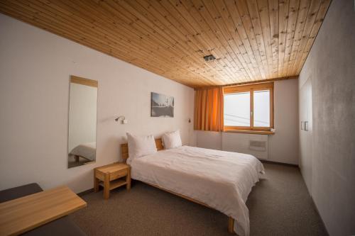 莱克斯GALAAXY Mountain Hostel的一间卧室设有一张带木制天花板的大床
