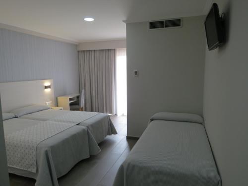 阿兰扎达Hotel La Lanzada的酒店客房设有两张床和电视。
