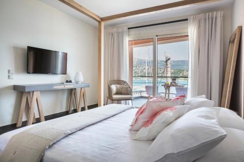 阿尔戈斯托利翁Argostoli Marina Suites的一间卧室配有一张带书桌和电视的床。