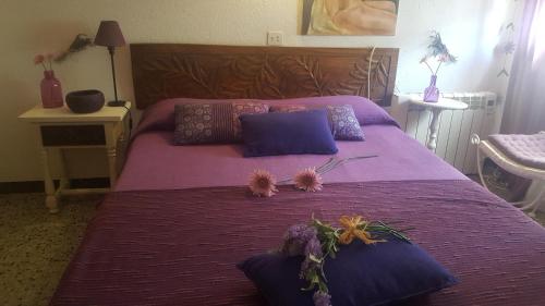 德拉塞尔瓦港Fonda Felip的紫色的床,上面有枕头和鲜花