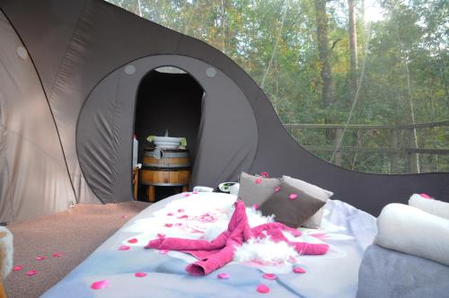 FisenneSphair perchée的黑色帐篷内的一张床位,里面饲养着粉红色的填充动物