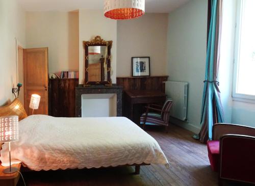CrespinLes Trois Hiboux的一间卧室配有一张床、一张书桌和一面镜子
