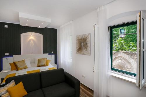 斯普利特费克提里公寓的一间卧室配有一张床、一张沙发和一个窗口
