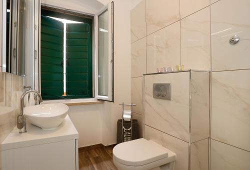斯普利特费克提里公寓的浴室配有卫生间、盥洗盆和淋浴。