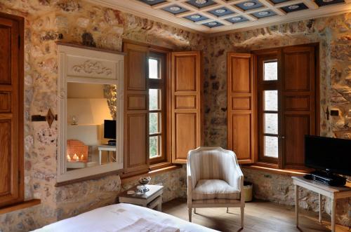 利昂尼迪翁阿尔冲提古奇欧提酒店的一间卧室配有一张床、一把椅子和电视