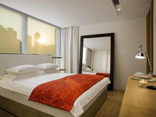 香港哲維斯酒店的一间卧室配有一张大床和镜子