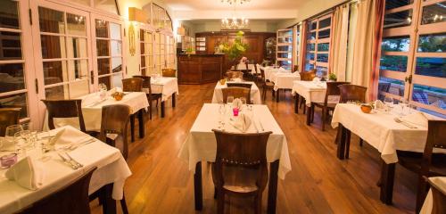 法兰西堡因贝拉特里斯酒店的一间餐厅,房间内设有白色的桌椅