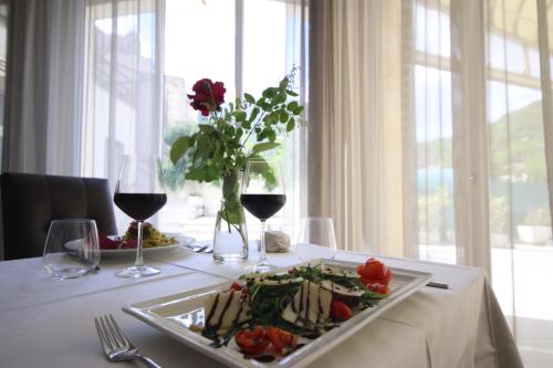 真加Hotel Terme di Frasassi的一张桌子,上面放着一盘食物和酒杯