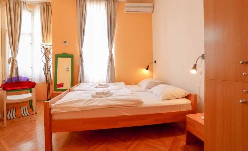 萨拉热窝Pigeon Square Rooms的一间卧室配有一张带白色床单的床和一扇窗户。