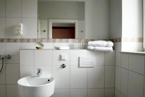 PrierosCellino Hotel Prieros的白色的浴室设有水槽和镜子