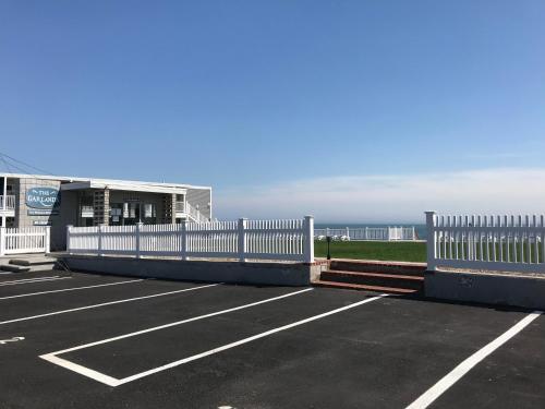 丹尼斯港花环汽车旅馆的海边的停车场设有白色围栏