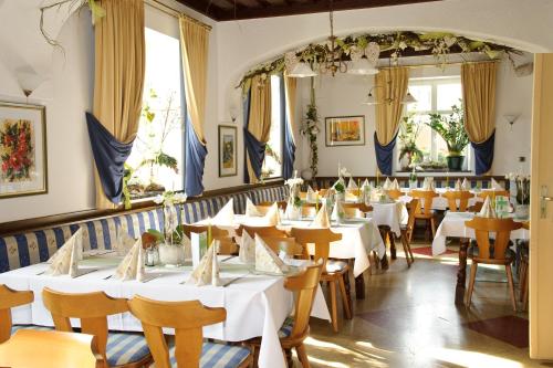 比绍夫斯迈斯赫尔蒙斯霍夫旅馆的一间设有白色桌椅的用餐室