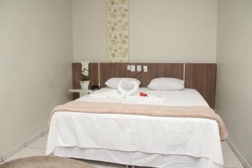 ItaitubaHotel Acai的一间卧室配有一张带两个天鹅的床