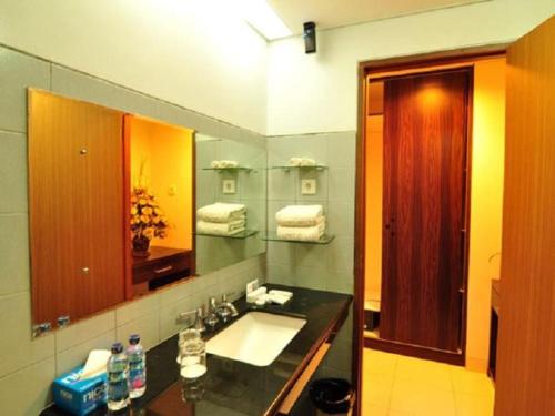 吉打邦ASTON Ketapang City Hotel的一间带水槽和镜子的浴室